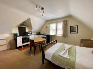 a bedroom with a bed and a table and a kitchen at Noa Residence in Oxford