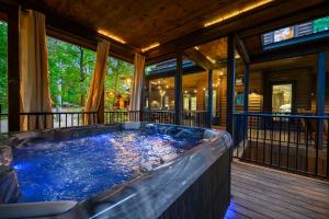 a large hot tub on a screened porch with at Call It A Day Luxury Cabin in Stephens Gap