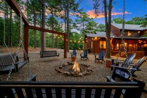 a patio with swings and a fire pit in front of a log cabin at Call It A Day Luxury Cabin in Stephens Gap