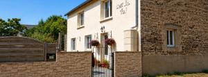 a white house with a gate and a brick building at C'est la vie in Saint-Malo des 3 Fontaines