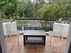 a porch with two chairs and a table and a fence at Gurudeva stay inn in Covelong