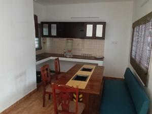 a kitchen with a table and chairs in a room at Gurudeva stay inn in Covelong