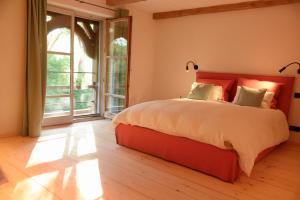 a bedroom with a large bed and a large window at Das versteckte Nest in Seeon-Seebruck