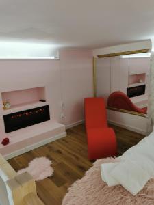 a living room with a red chair and a mirror at La Seventies'room in Dijon +9 photos