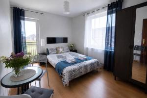 a small bedroom with a bed and a table at Szept Fal & Minigolf in Rewal +16 photos