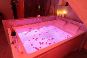 a bath tub filled with lots of red hearts at La Seventies'room in Dijon