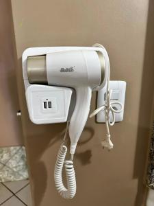 a hair dryer is hanging on a wall at Hotel A DOIS adults only in Jataí