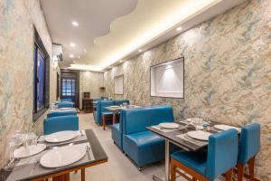 a dining room with tables and blue chairs at Treebo Planet Mount Near US Consulate Anna Salai in Chennai