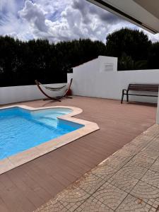a swimming pool with a hammock on a patio at Monte Santo in Montargil