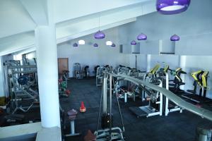 a gym with lots of tread machines and purple lights at Karev Sport Hotel in Gümüşyaka