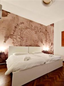 a bedroom with a large white bed with two towels at DOMUS GALLA PLACIDIA - superlative view - 50 meters from UNESCO heritage sites - San Vitale - Galla Placidia in Ravenna