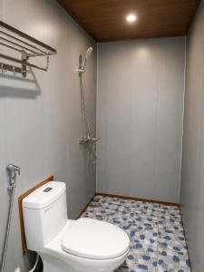 a bathroom with a white toilet and a tile floor at Haven Kitchen & Cafe in Nguyễn Thôn