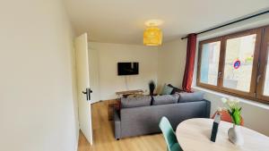 a living room with a couch and a table at Le Tertre du Loing - Forêt de Fontainebleau - Gare in Montigny-sur-Loing