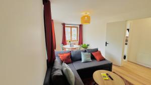 a living room with a couch and a table at Le Tertre du Loing - Forêt de Fontainebleau - Gare in Montigny-sur-Loing +16 photos