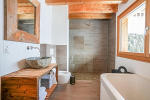 a bathroom with a sink and a tub and a toilet at Chalet t'Alpa in Bettmeralp