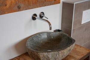 a bathroom with a stone sink with a faucet at Chalet t'Alpa in Bettmeralp