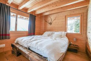 a bedroom with a bed in a log cabin at Chalet t'Alpa in Bettmeralp