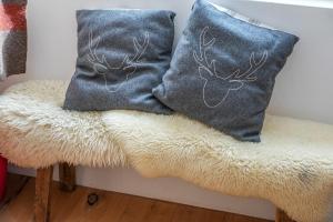 two pillows with deer heads on them sitting on a bench at Chalet t'Alpa in Bettmeralp +34 photos
