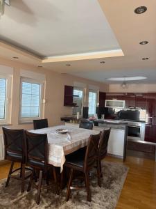 a kitchen and dining room with a table and chairs at Prishtina Luxury House in Laplje Selo