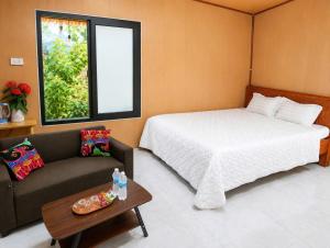 a bedroom with a bed and a couch and a window at Haven Kitchen & Cafe in Nguyễn Thôn