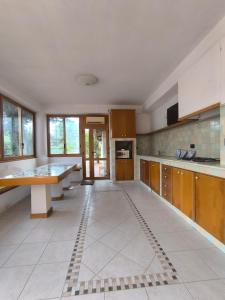 a large kitchen with wooden cabinets and a tile floor at Villa Sunrise in Casteldaccia