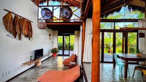 a living room with a fireplace and a table and chairs at Serena Pousada - Icaraí de Amontada in Icaraí