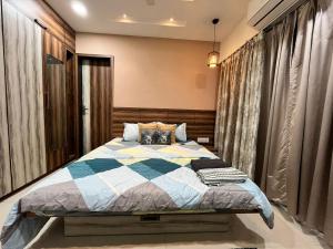 a bedroom with a bed with a checkered blanket at Spacious 4 BHK flat- 4 Beds in Indore