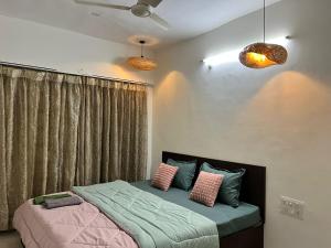a bedroom with a bed with pink and green pillows at Spacious 4 BHK flat- 4 Beds in Indore