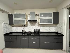 a kitchen with a black counter top and microwave at Spacious 4 BHK flat- 4 Beds in Indore