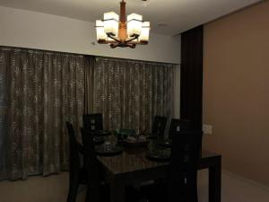 a dining room table with chairs and a chandelier at Spacious 4 BHK flat- 4 Beds in Indore +4 photos