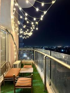 a balcony with a table and chairs and lights at Spacious 4 BHK flat- 4 Beds in Indore