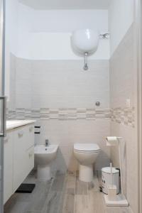 a white bathroom with a toilet and a sink at La Torre Guelfa in Iglesias
