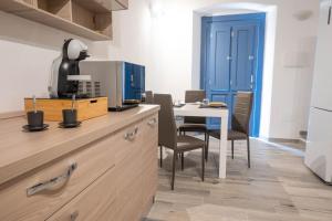a kitchen with a table and a blue door at La Torre Guelfa in Iglesias +4 photos