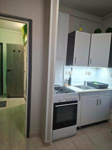 a kitchen with a stove top oven next to a sink at Zöld otthon in Szeged