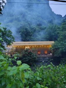 a building with lights in front of a mountain at Haven Kitchen & Cafe in Nguyễn Thôn