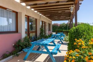 a row of blue picnic tables next to a building at ibis budget Narbonne Sud A9/A61 in Narbonne