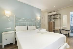 a bedroom with a large white bed with white pillows at MR Hotelet de la Raconà & Apartments in Denia +181 photos