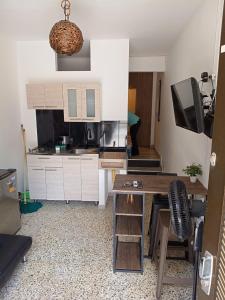 a kitchen with white cabinets and a table and chairs at Apartamento C&B in Bello