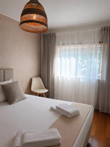 a bedroom with a large white bed and a window at Casa do Pirata by GuestPro in Matosinhos