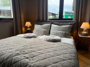 a bedroom with a large bed with pillows and two lamps at Ośrodek Wypoczynkowo Sportowy Pod Żurawiem Ap 3 in Karolewo