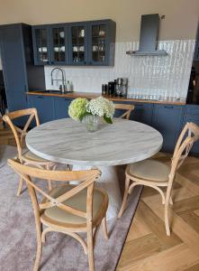 a kitchen with a table and chairs with a vase of flowers at Ośrodek Wypoczynkowo Sportowy Pod Żurawiem Ap 3 in Karolewo