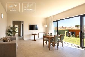 a dining room and living room with a table and chairs at Suites Del Borgo in Olbia