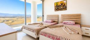 two beds in a bedroom with a large window at Healthy Apartments Abelia Residence in Iskele +30 photos