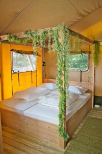 a bedroom with a bed with ivy on it at Boeren glamping De Ruif De Peppelhoeve in Stoutenburg