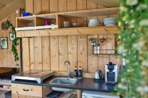 a kitchen with a sink and a counter top at Boeren glamping De Ruif De Peppelhoeve in Stoutenburg +27 photos