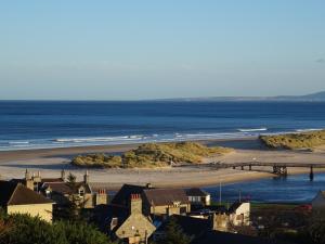 Una vista de una playa con un muelle y el océano. en Lossiemouth Haven, en Lossiemouth 16 fotos más
