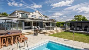 a backyard with a swimming pool and a house at Architectural Gem with Luxury Outdoor Kitchen in Chilham