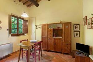 a living room with a table and a tv and a kitchen at Le Civette Country Resort with Pool in Bagno a Ripoli