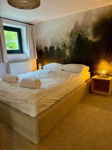 a bed in a bedroom with a painting on the wall at Hi Wisła in Wisła