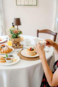 a woman sitting at a table with a cup of coffee at Agriturismo Costa Arènte in Grezzana +6 photos